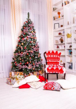 Noel Baba için rahat bir yer. Ağaç farklı taşaklarla süslenmiş ve yanında çocukları tebrik etmek için Noel Baba sandalyesi var.