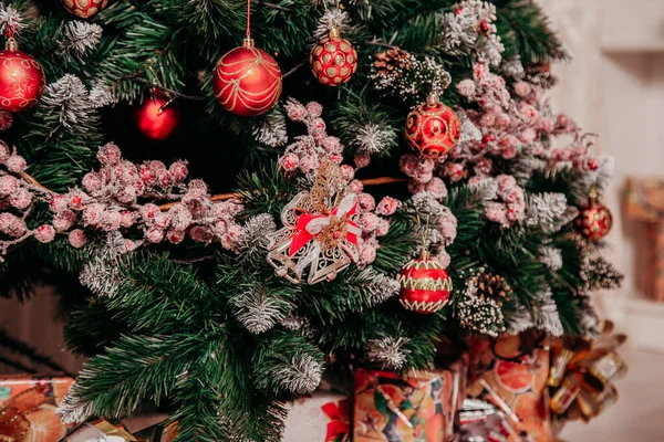 Renkli oyuncaklarla süslenmiş Noel ağacı ve kurdeleli toplar