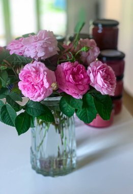 A vase filled with rose centifolia on a table