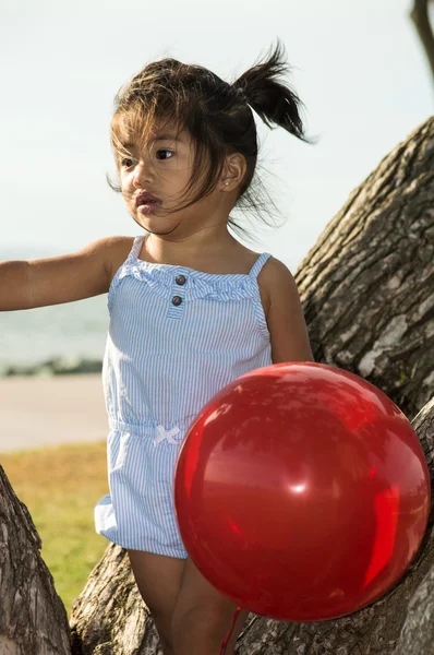 Κοριτσάκι σε ένα δέντρο με μπαλόνι — Φωτογραφία Αρχείου