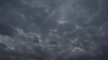 Rüzgar gökyüzünde yoğun fırtına bulutları taşır. Yumuşak görüntü. Hızlandırılmış video. Kamerada küçük bir hareket ve sallanma var..