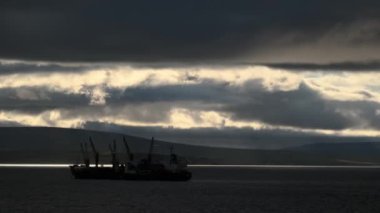 Lavrentiia, Chukotski bölgesi, Rusya - 25 Temmuz 2020: Rüzgar gökyüzünde ağır gri bulutlar sürüyor. Denizde gemiler var. Kamerada küçük bir hareket ve sallanma var..