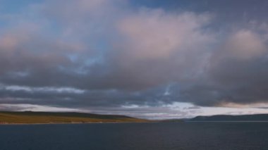 Bulutlar denizin ve kıyı şeridinin üzerinde uçar.