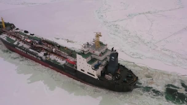 俄罗斯提曼地区萨贝塔 2021年4月7日 亚马尔破冰船在冰上拖曳楚科奇号油轮 阴云密布 下着小雪 — 图库视频影像