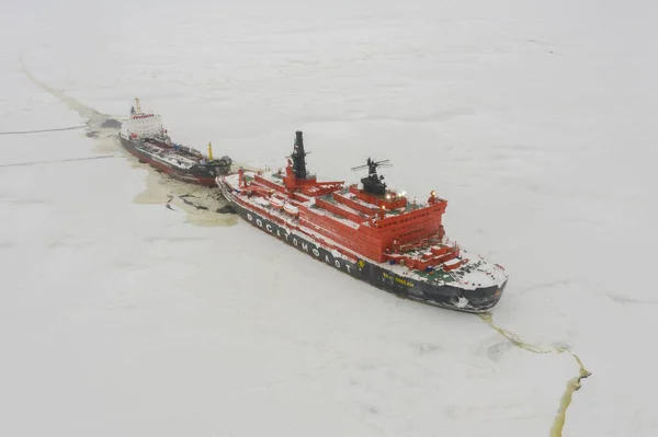 Sabetta, Tyumen bölgesi, Rusya - 4 Nisan 2021: 50, Pobedy 'nin buz üzerinde bir tankeri çekmesine izin verdi. Bulutlu, hafif kar yağıyor.