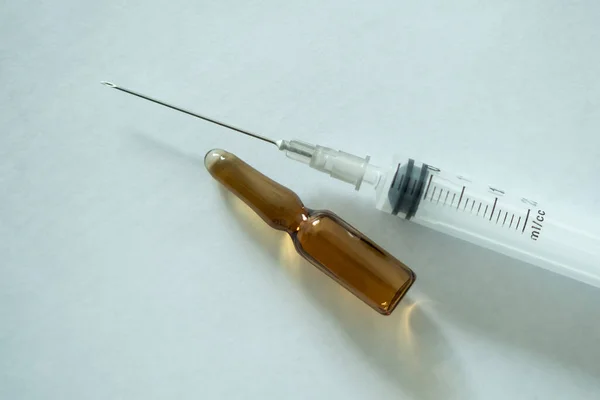 桌上放着一个带有疫苗和注射器的医疗座圈 — 图库照片