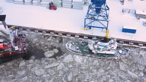ロシアのアルカンゲルスク 2021年2月14日 ばら積み貨物船は海のタグボートによって氷の上に曳航されています — ストック動画