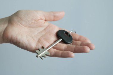 Kapı kilidinden anahtarı tutan el..