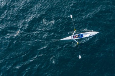 Sporcu suda kanoyla kürek çeker..