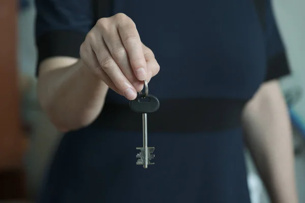 Kapı kilidinden anahtarı tutan el..