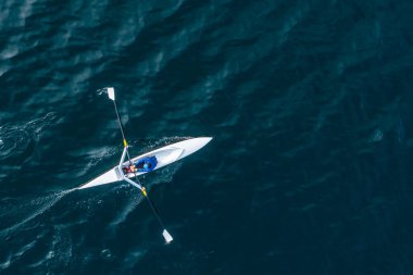 Sporcu suda kanoyla kürek çeker..