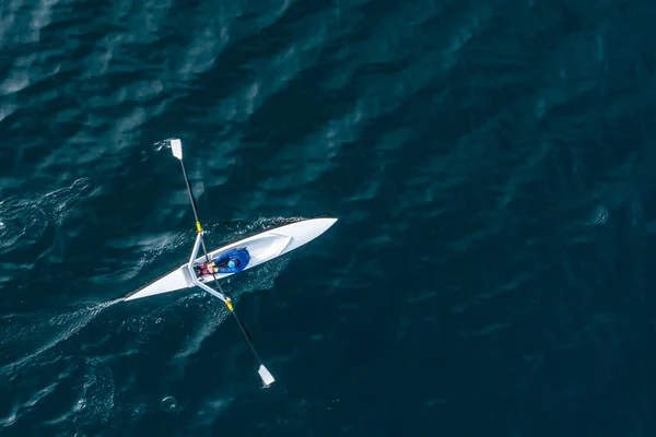 Sporcu suda kanoyla kürek çeker..
