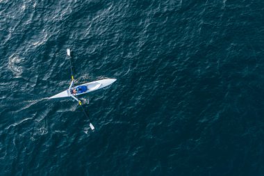 Sporcu suda kanoyla kürek çeker..