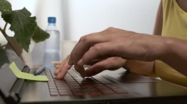 Eller dizüstü bilgisayarda çalışır. Dizüstü bilgisayarda çalışan kız pizza yiyor..