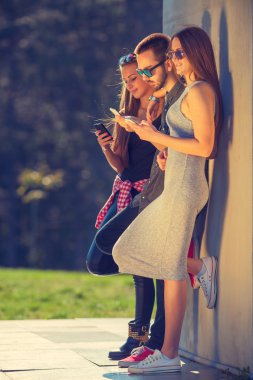 Eğleniyor ve telefonlarınızı kullanarak arkadaş grubu