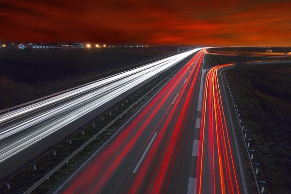 Sentiers lumineux sur l'autoroute au beau coucher du soleil — Photo