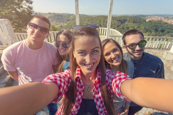 Jóvenes amigos divirtiéndose y tomando selfie al aire libre —  Fotos de Stock