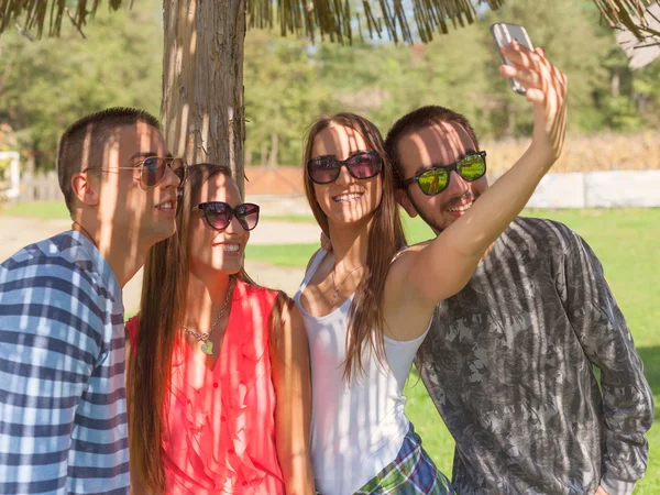 Mladí přátelé, mají zábavu a přijímání selfie venku — Stock fotografie