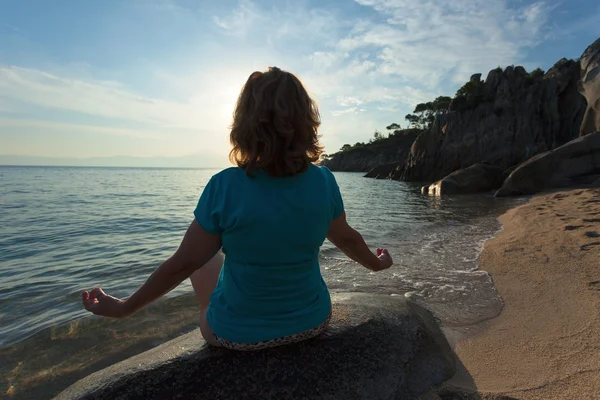 Kvinnor mediterar i yogaställning på stranden vid soluppgången — Stockfoto