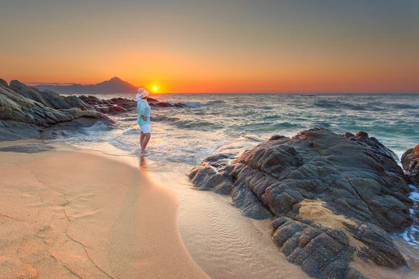 Kumlu sahilde güzel güneş doğarken kadının..... — Stok fotoğraf