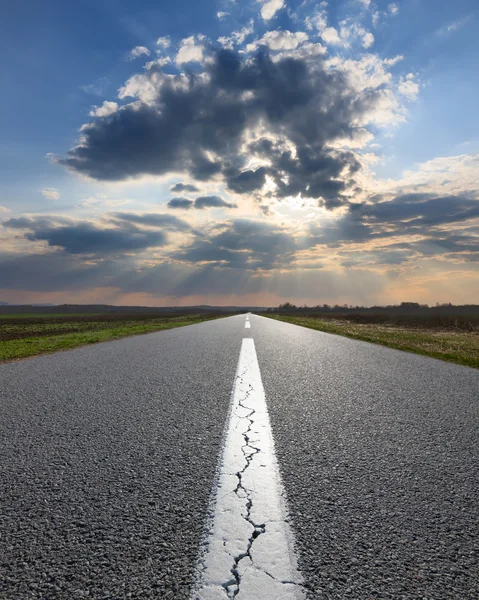 Auf leerer Straße der untergehenden Sonne entgegen — Stockfoto