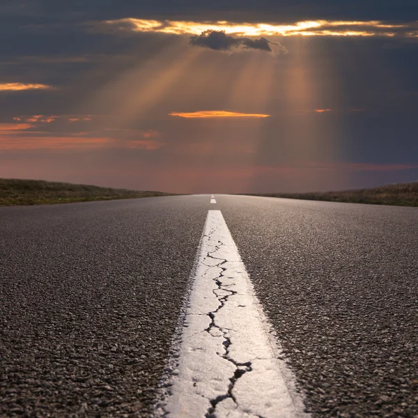 Conduciendo por un camino abierto y vacío hacia el sol poniente —  Fotos de Stock