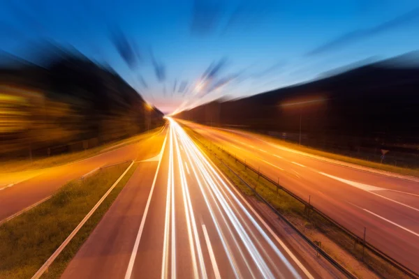 Autobahn mit Lichtspuren in der Dämmerung in verschwommener Bewegung — Stockfoto