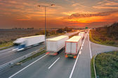 Několik nákladních automobilů v pohybu rozostření na dálnici