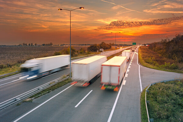 Varios camiones en movimiento borroso en la carretera — Foto de Stock