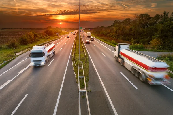 Twee witte vrachtwagens in motion blur op de snelweg — Stockfoto