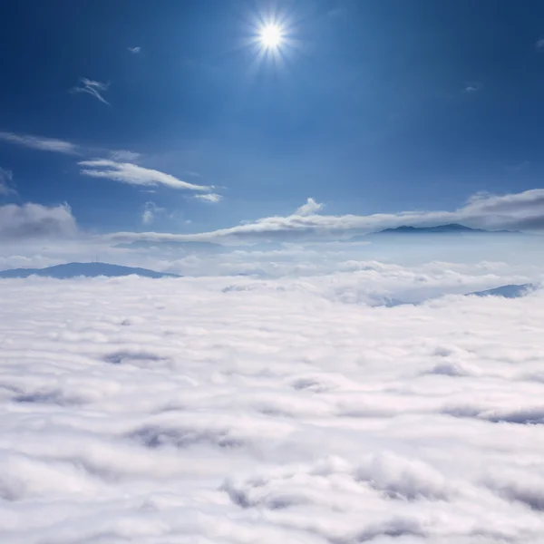 Tepeler karşı güneş bulutların üstünde — Stok fotoğraf