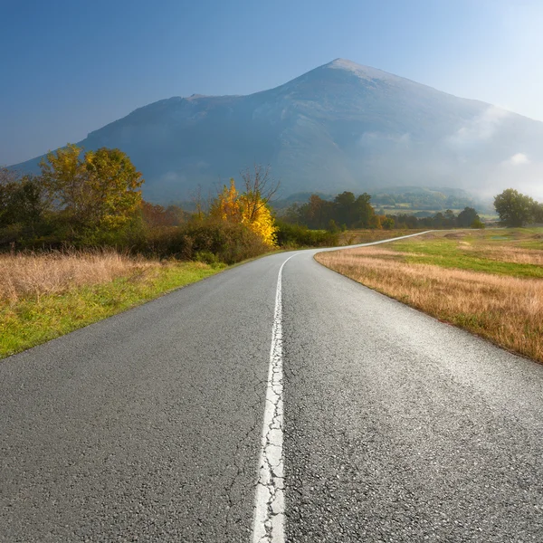 Empty road towards the mountain peak at morning — Stock Photo, Image
