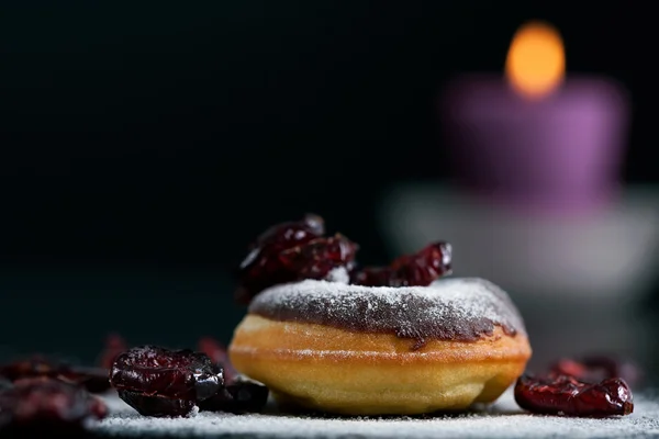 Donut topped with chocolate and cranberries