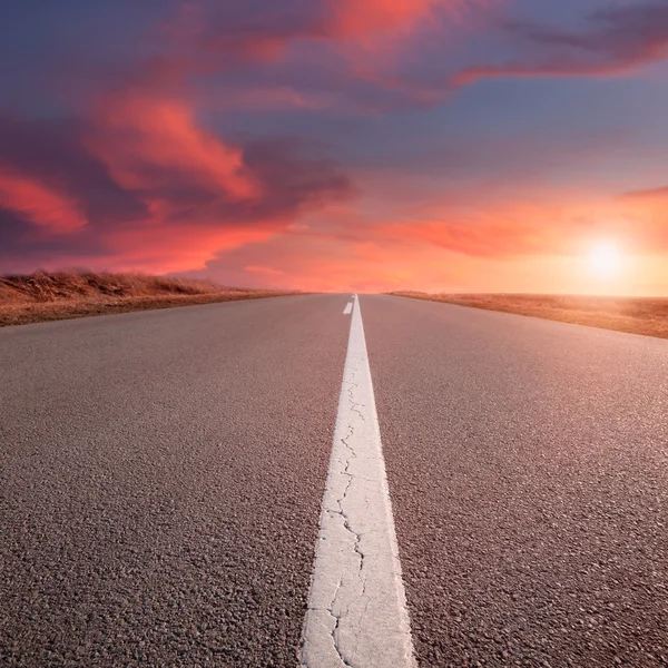 Condução numa estrada vazia ao pôr-do-sol — Fotografia de Stock