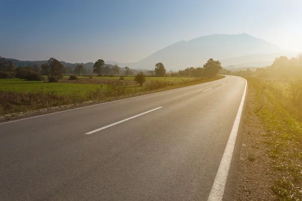 Driving on an empty road towards the mountain — Stock Photo, Image