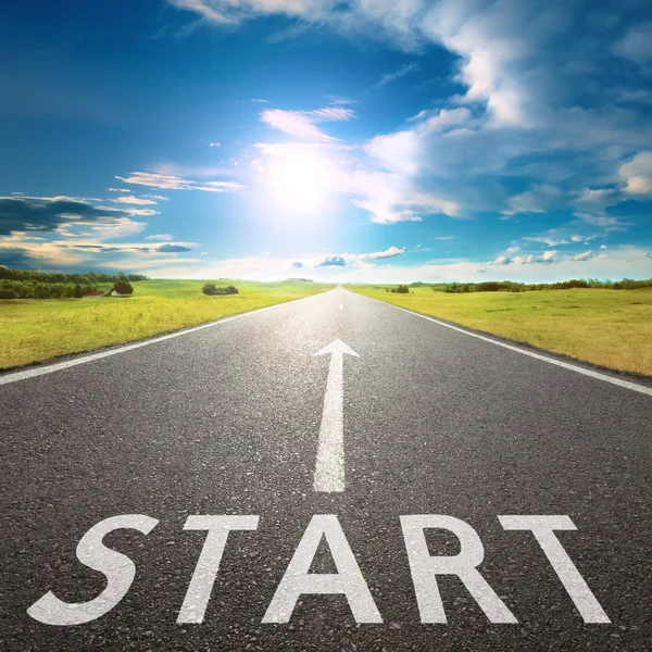 Empty asphalt road with a sign start against sun — Stock Photo, Image