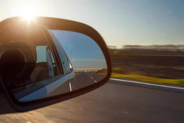 Espejo retrovisor y la puesta de sol desde el coche — Foto de Stock