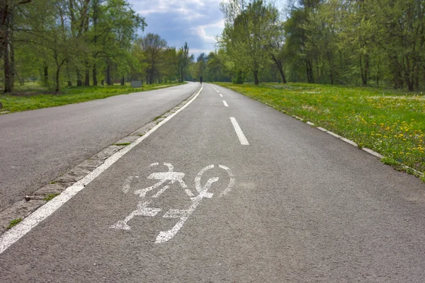 Trasa rowerowa z rowerów biały znak w parku miejskim — Zdjęcie stockowe