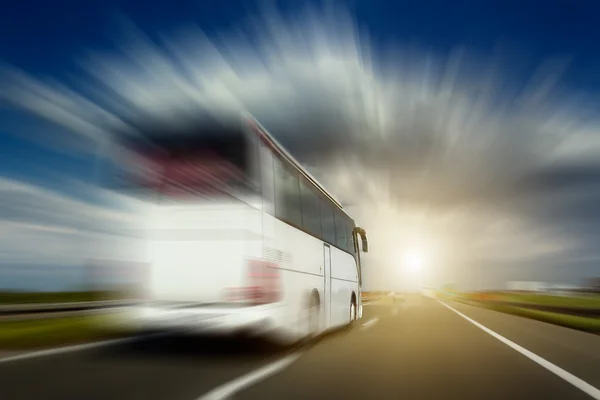 Ônibus branco em movimento desfoque ultrapassando a estrada — Fotografia de Stock