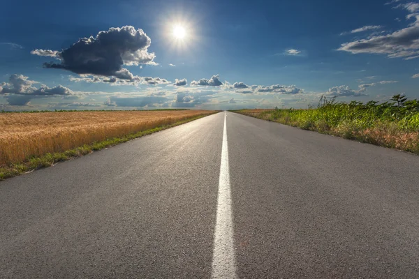 Driving on an empty asphalt road at sunset — Stock Photo, Image