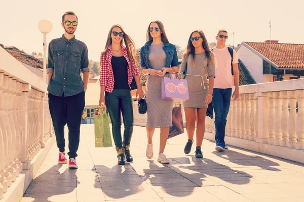 Друзья гуляют после шопинга в городе — стоковое фото