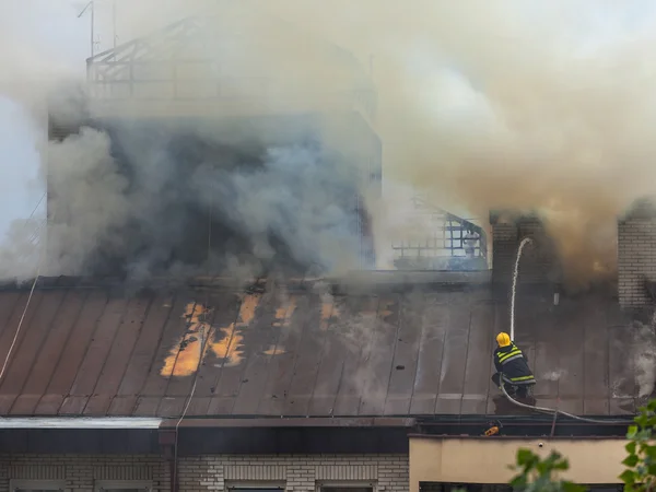 Feuerwehrmann beim Löschen des Dachstuhlbrands — Stockfoto