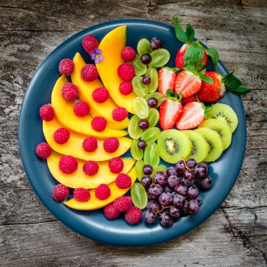 Renkli meyve ve çilek büyük mavi plaka üzerinde 