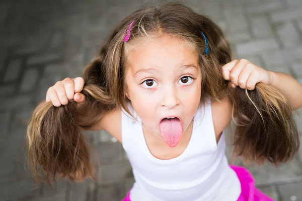 Little girl showing her tongue at the camera — Stock Photo, Image