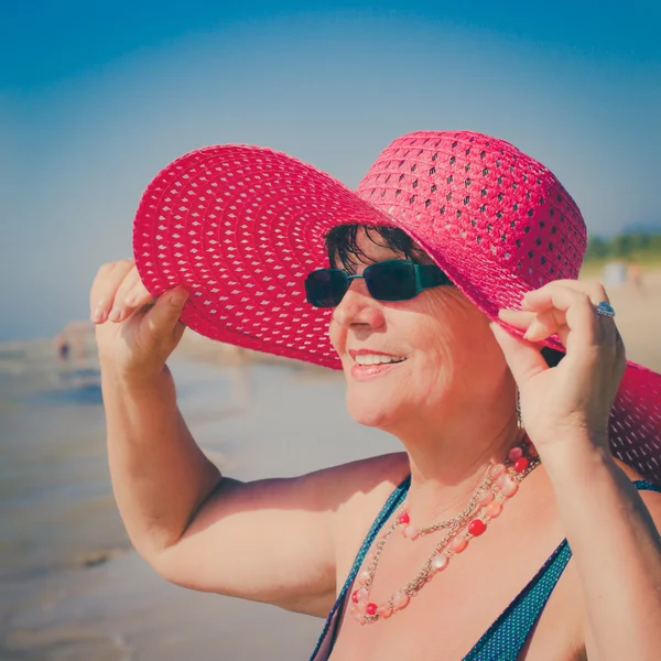 Kvinna med hatt på stranden — Stockfoto