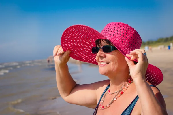 Kvinna med hatt på stranden — Stockfoto