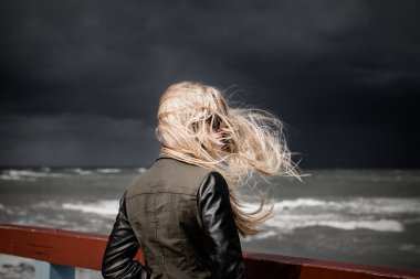 girl looking at stormy sea clipart
