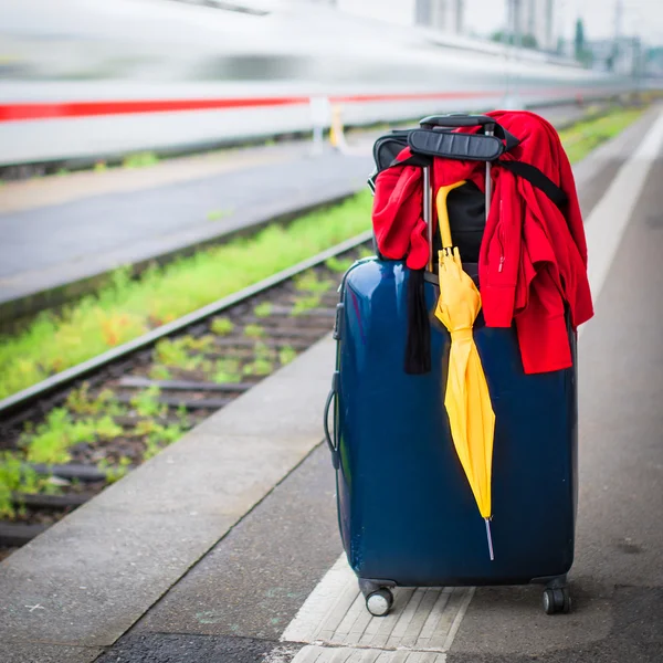 Suitcase with umbrella on platform — Stock Photo, Image