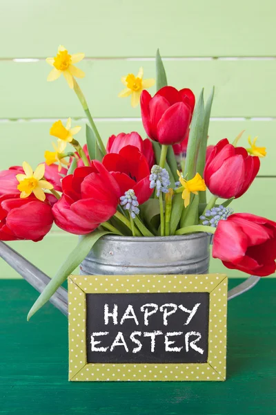 Red tulips in vintage watering can — Stock Photo, Image