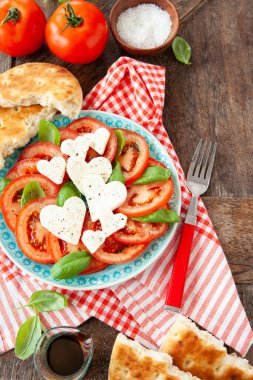 Taze domates salatası, mozzarella peyniri, kalp şeklinde fesleğen.